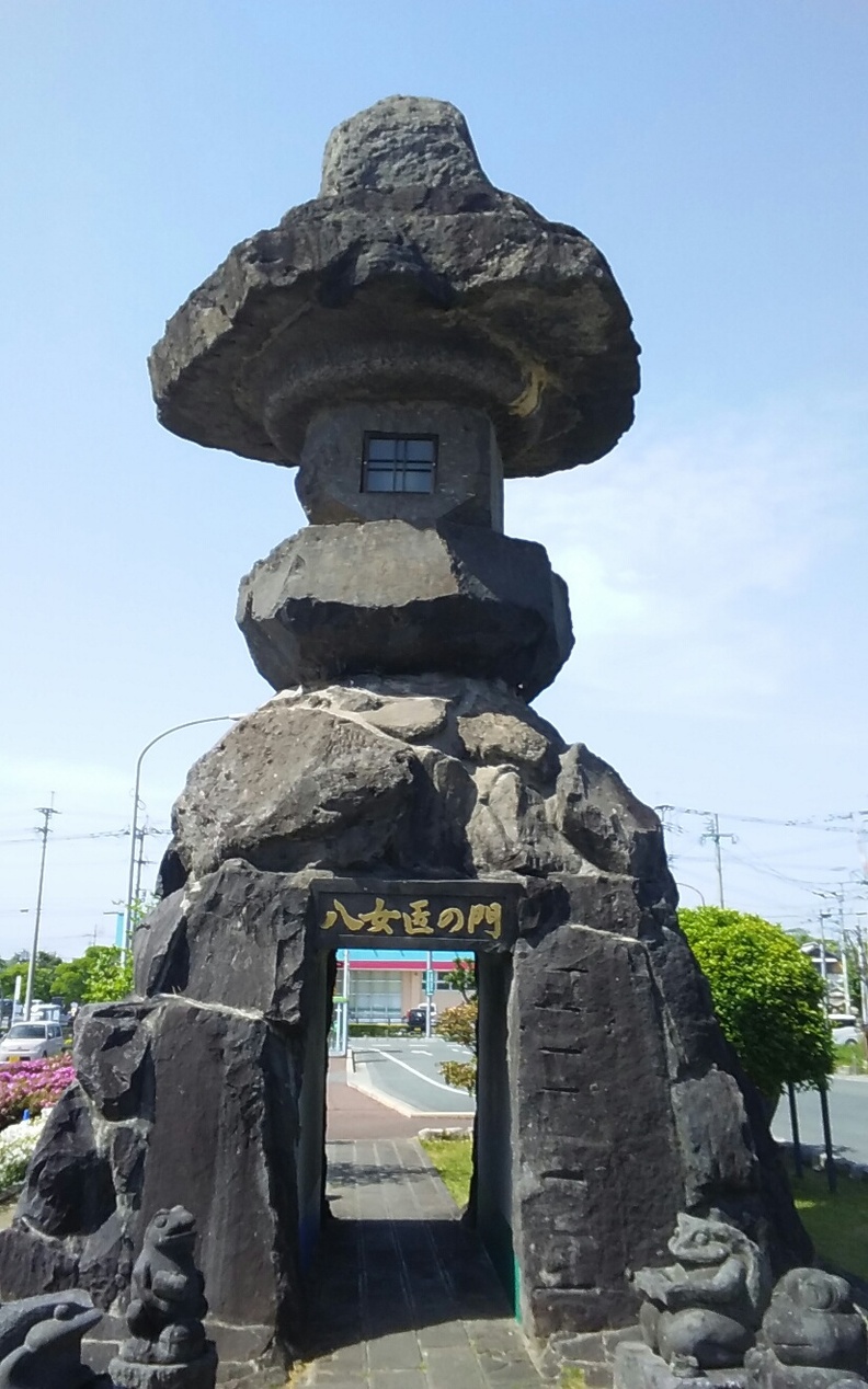En traditionell japansk stenlanterna, en tōrō, som står som ett minnesmärke mot en klar himmel.